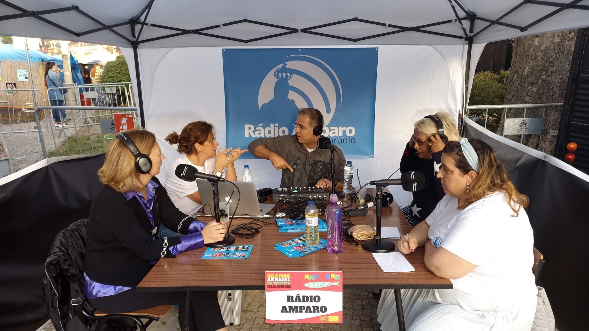 Emissão da Rádio Amparo no Grande Arraial de Benfica de 2022, debaixo de um toldo